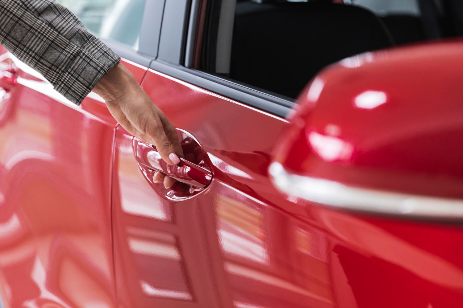 A person is grabbing a car door handle