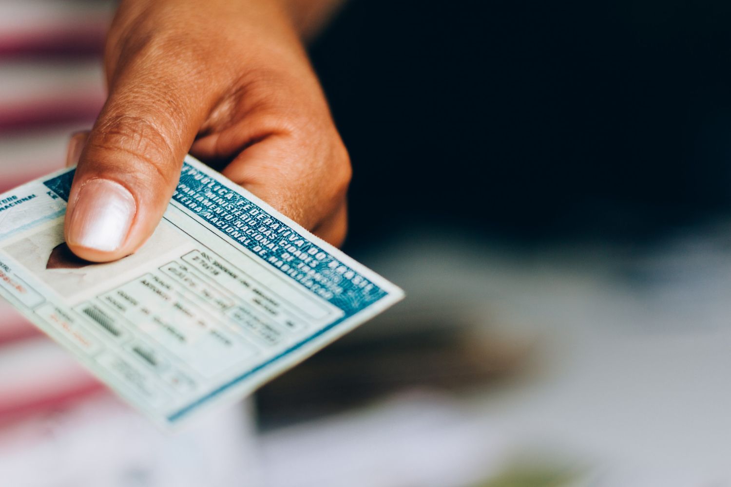 A hand extends a blue and white official document