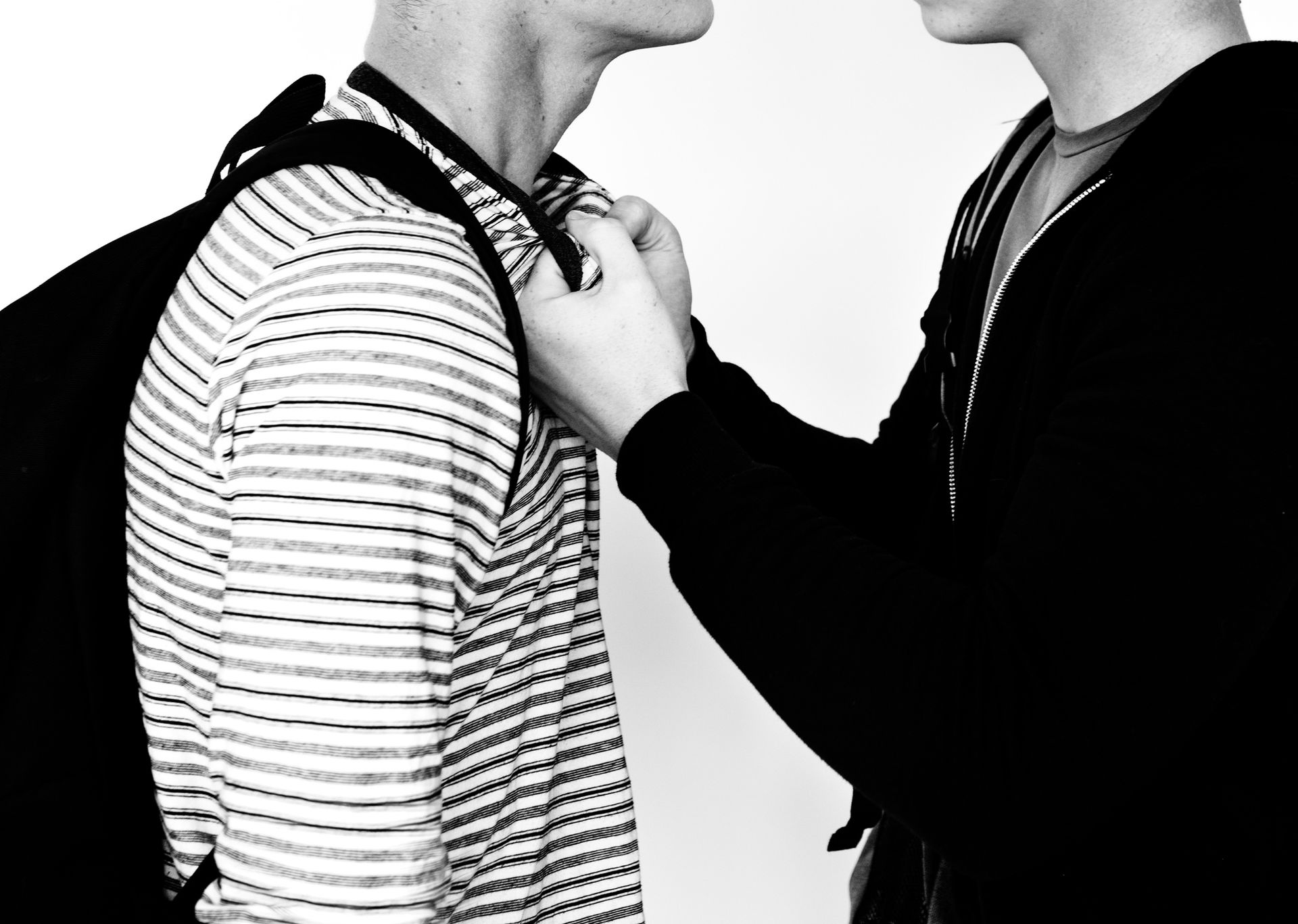 A black and white close-up of two men in a tense confrontation