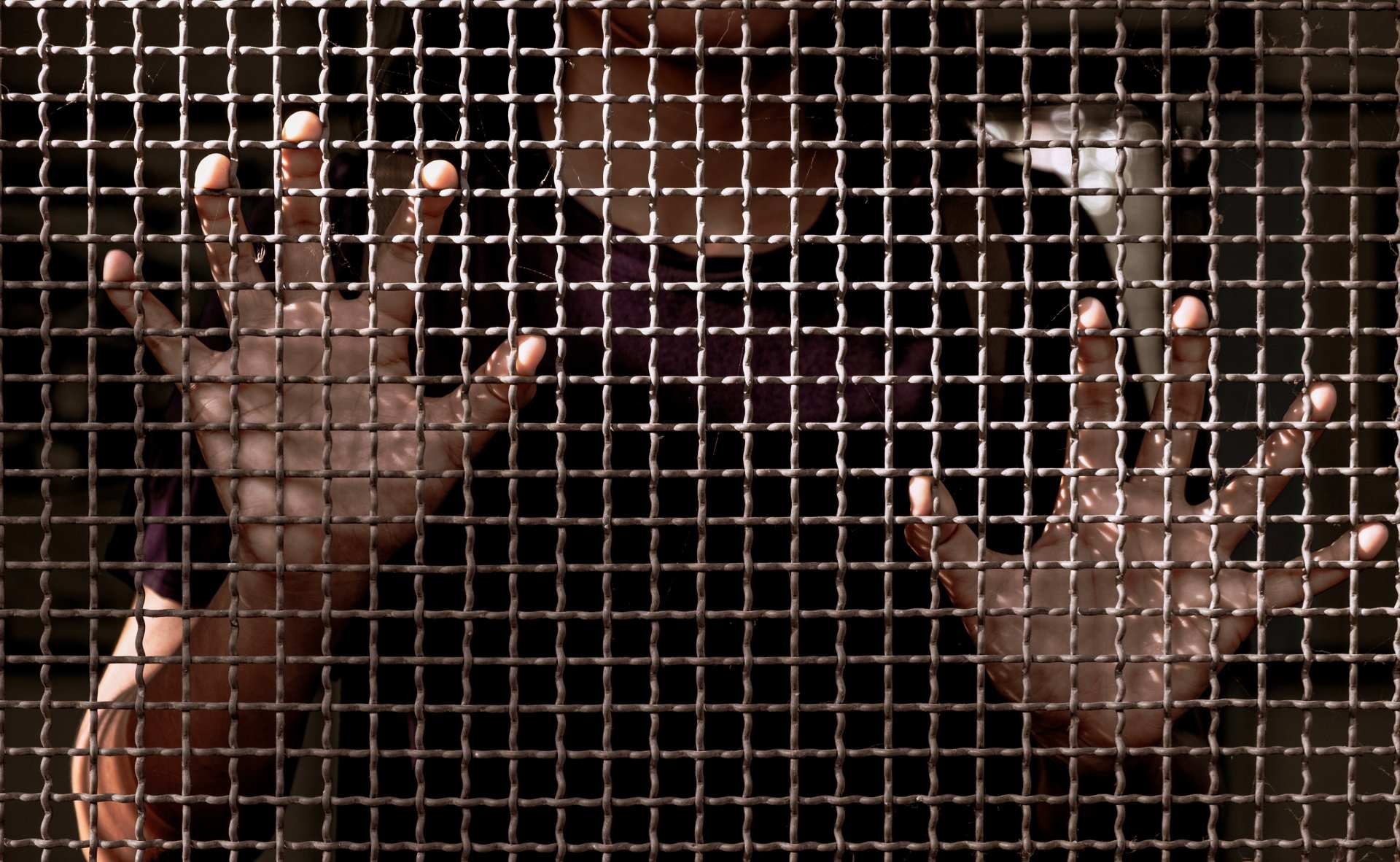 A person is reaching out from the inside the screen